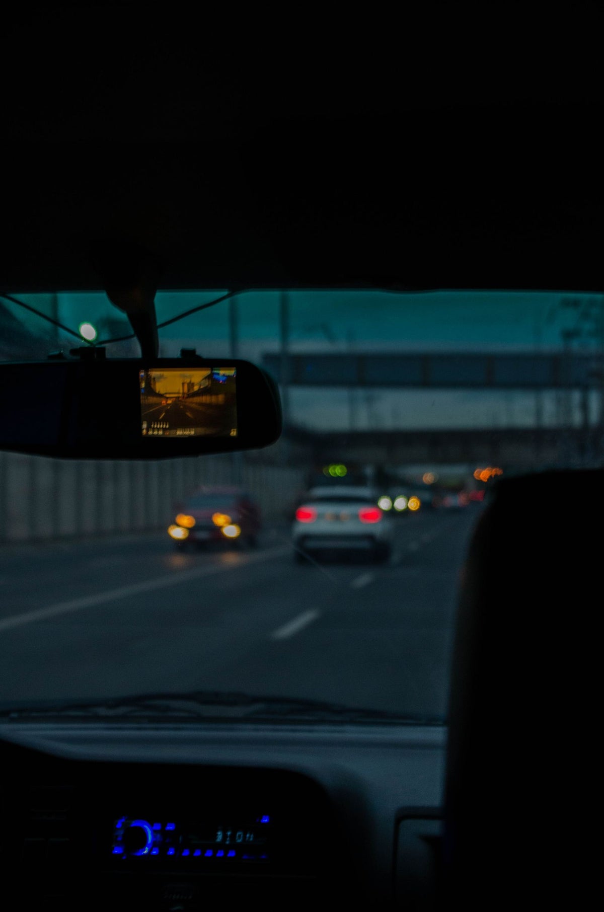 Dash camera recording a highway at night from inside a car