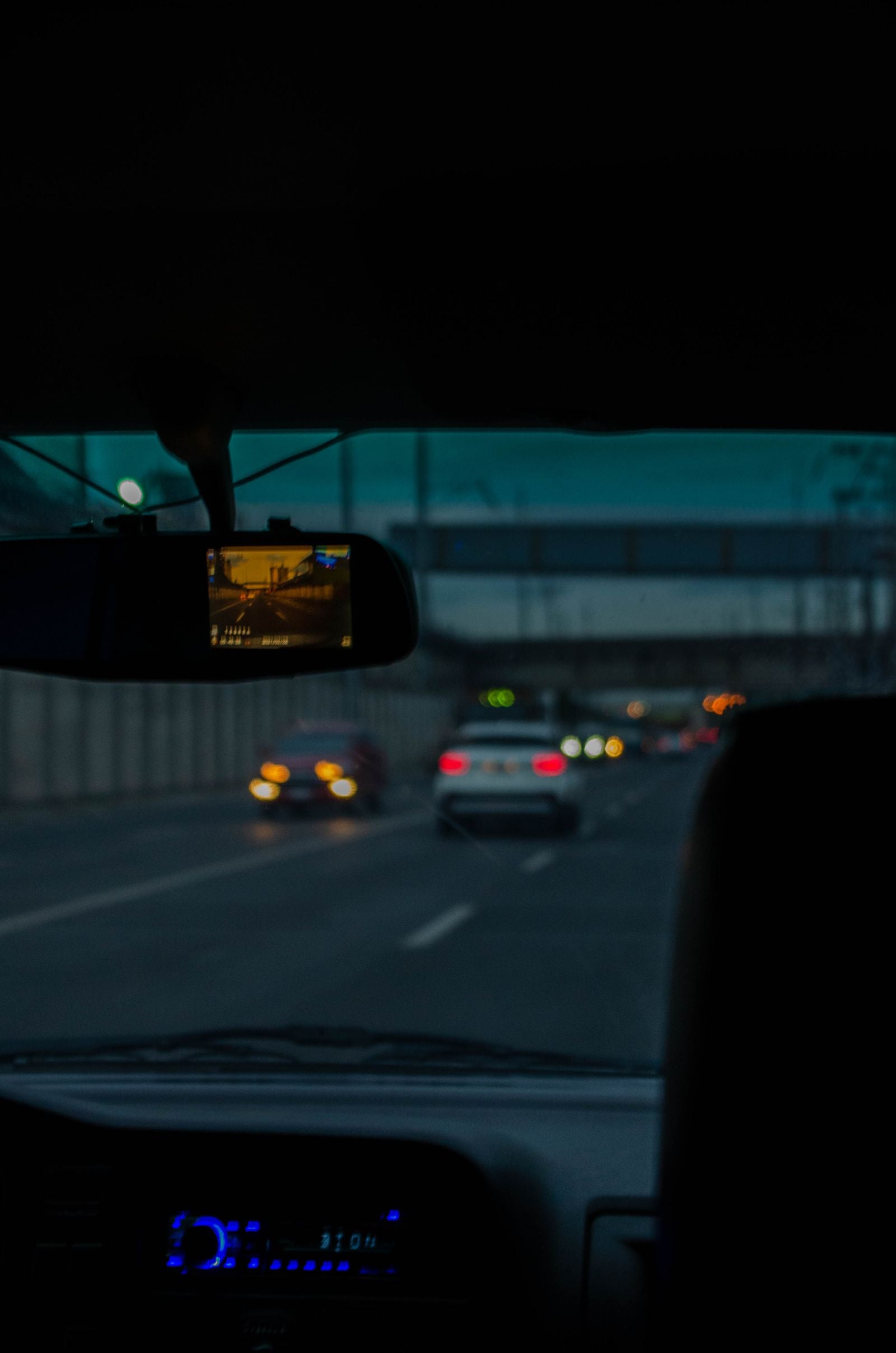 Dash camera recording a highway at night from inside a car